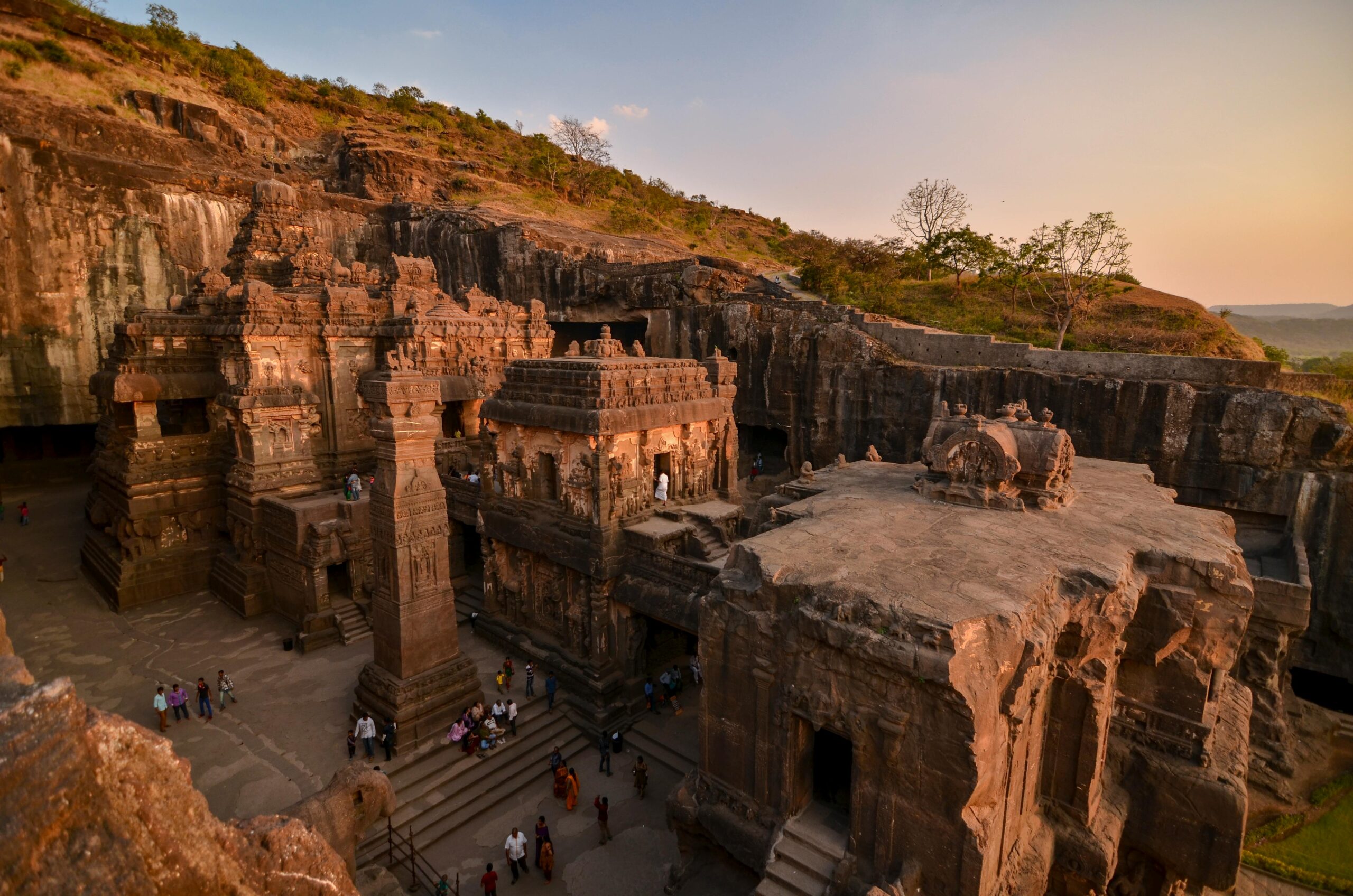 A breathtaking view of the ancient Ellora Caves captured at sunset, showcasing intricate stone carvings.